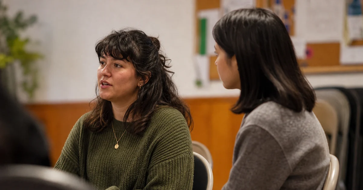 Two people in a workshop room having a quiet active listening conversation